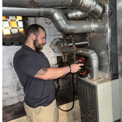 Logan, Weatherization Auditor for Community Action, Inc., conducts a furnace test to assess operating efficiency and identify potential safety issues during a home energy audit for the WARM and State Weatherization Projects.  